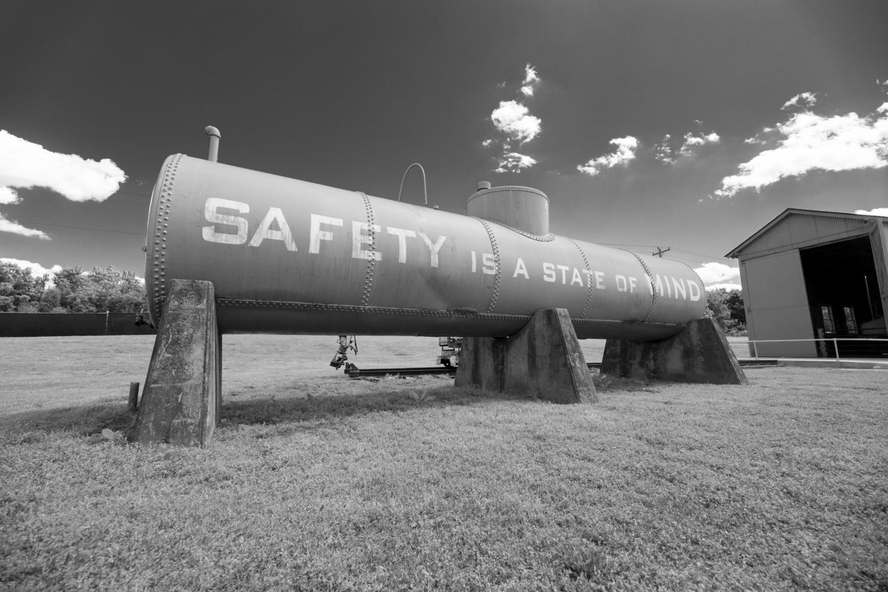services-01 Black and white image of industrial tank with 'Safety is a state of mind' text.