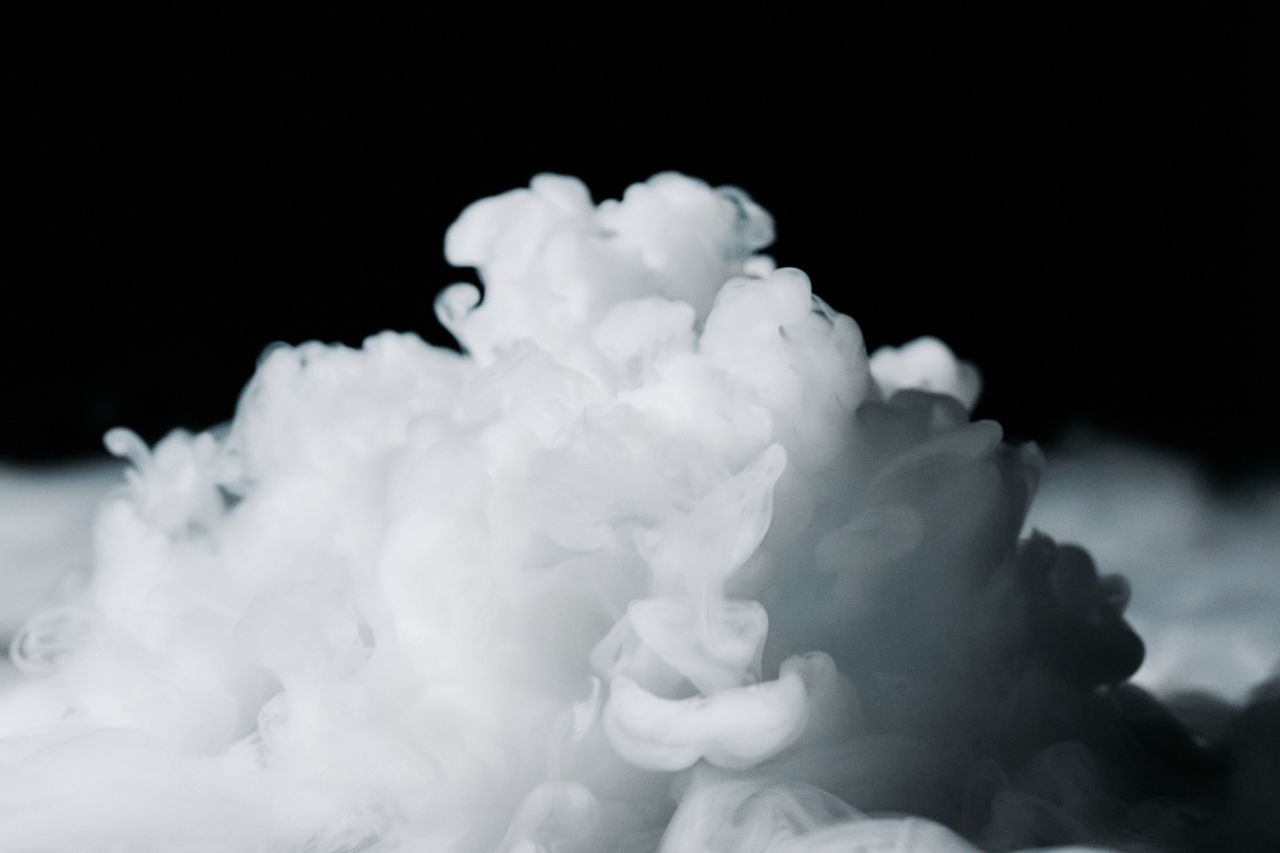 services-02 Cloud of white smoke on a dark background creating a dramatic and abstract effect.